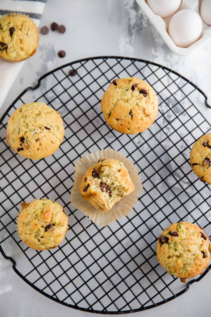 a zucchini muffin with a bite taken out surrounded by other muffins