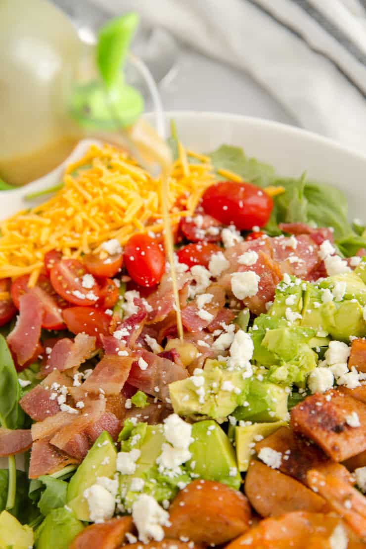 dressing poured on the cobb salad