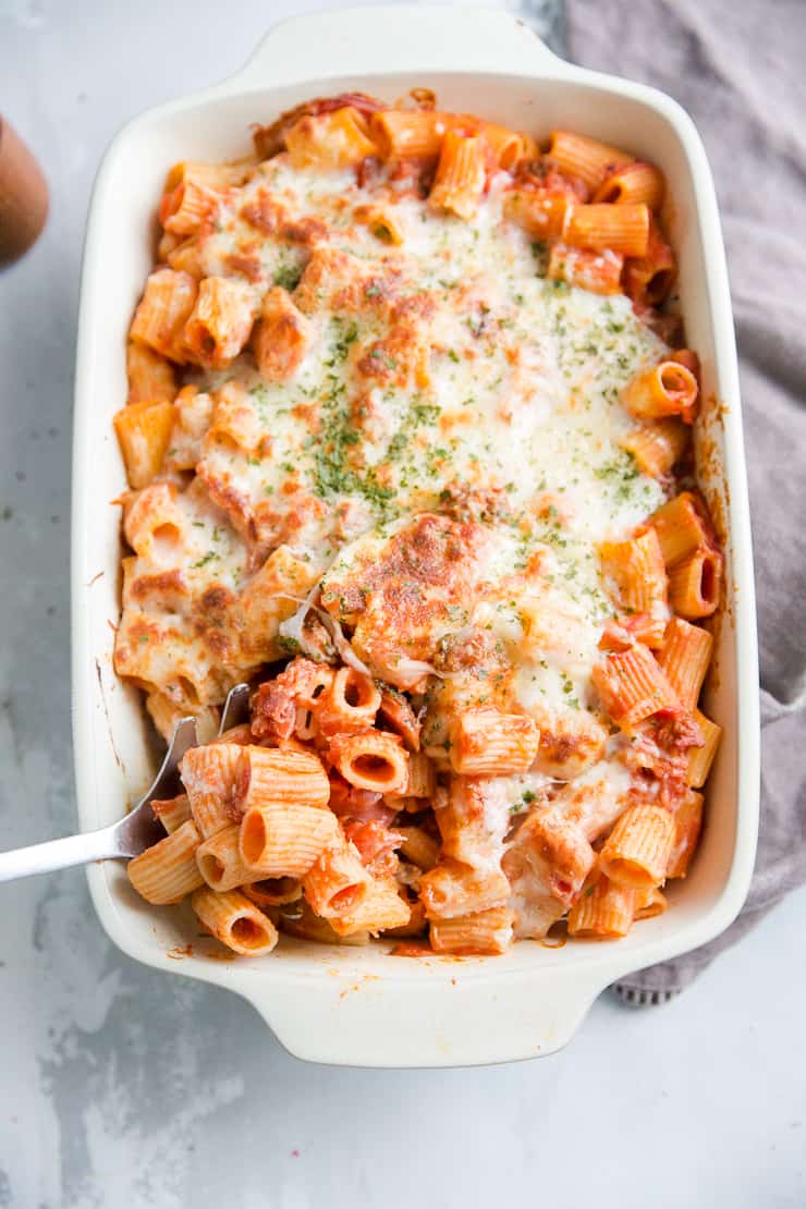 baked rigatoni dish with serving spoon