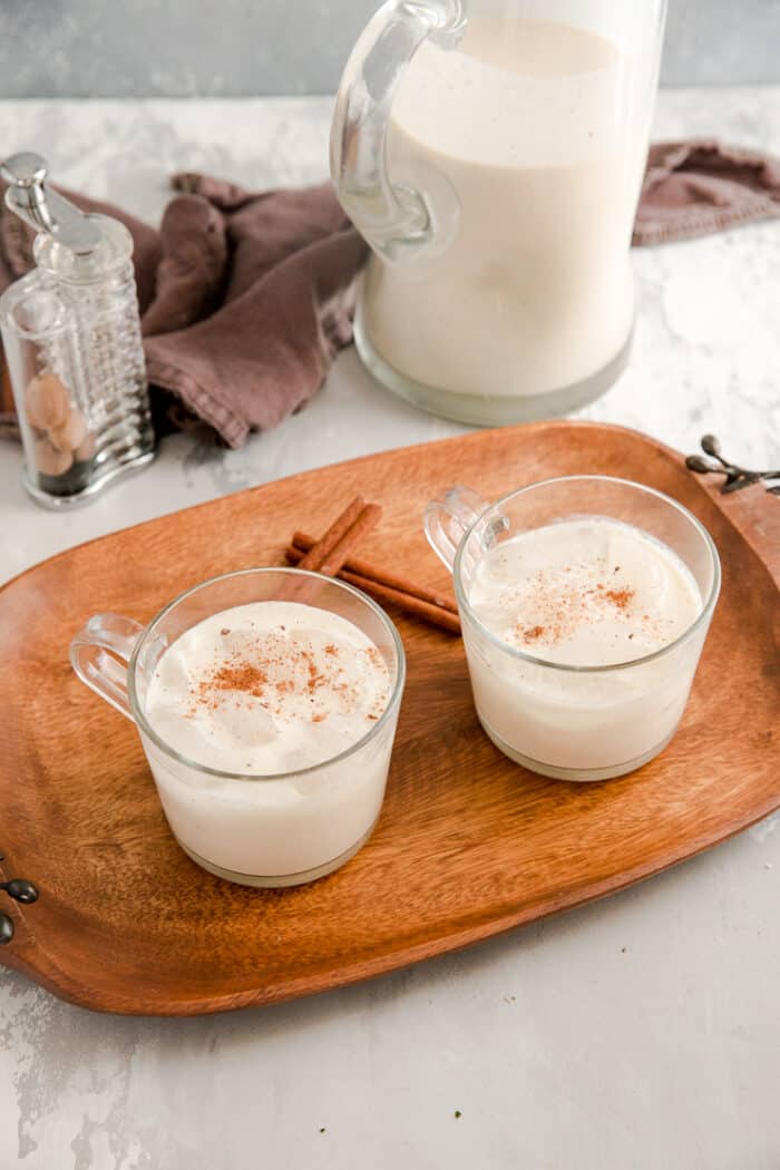 two glasses of coquito on a tray