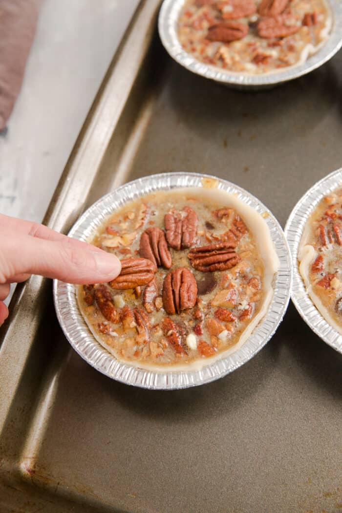 placing a pecan on an unbaked pie