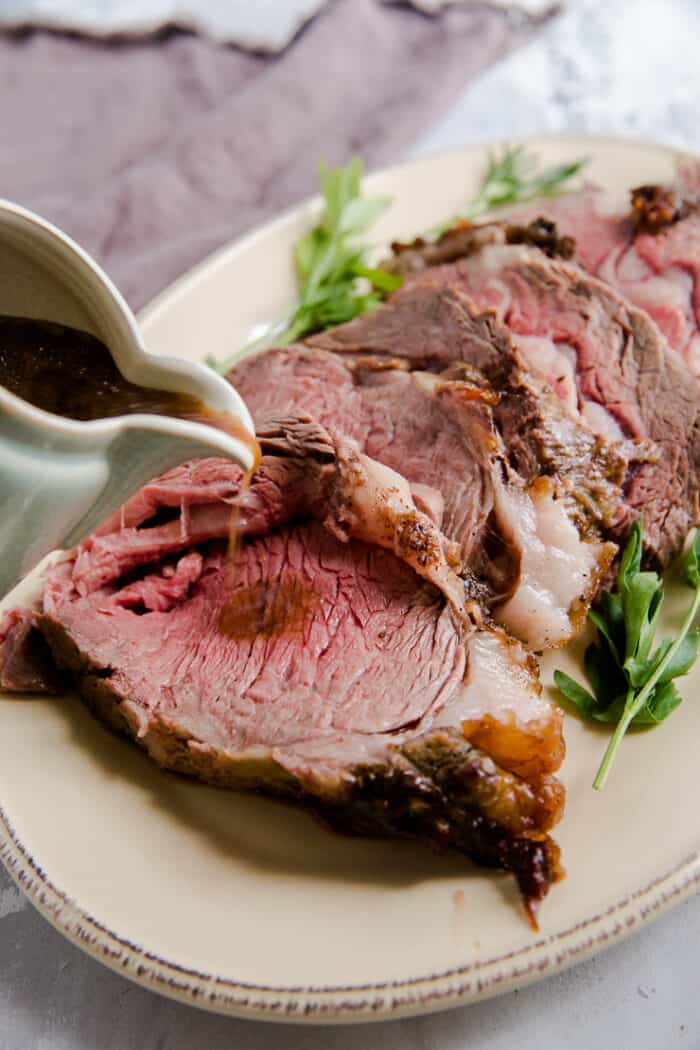 sliced prime rib on a platter with au jus