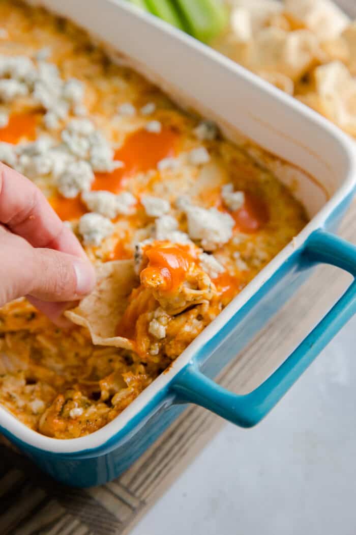 buffalo chicken dip with a person getting a scoop