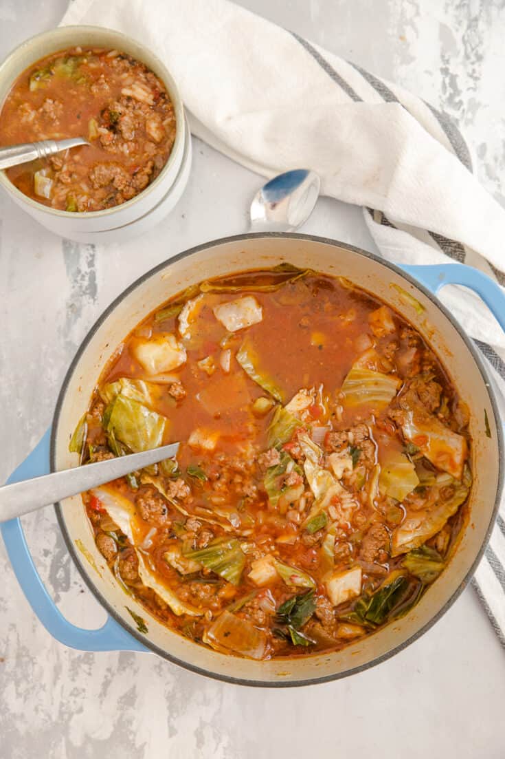 cabbage roll soup in a dutch oven with a bowl on the side