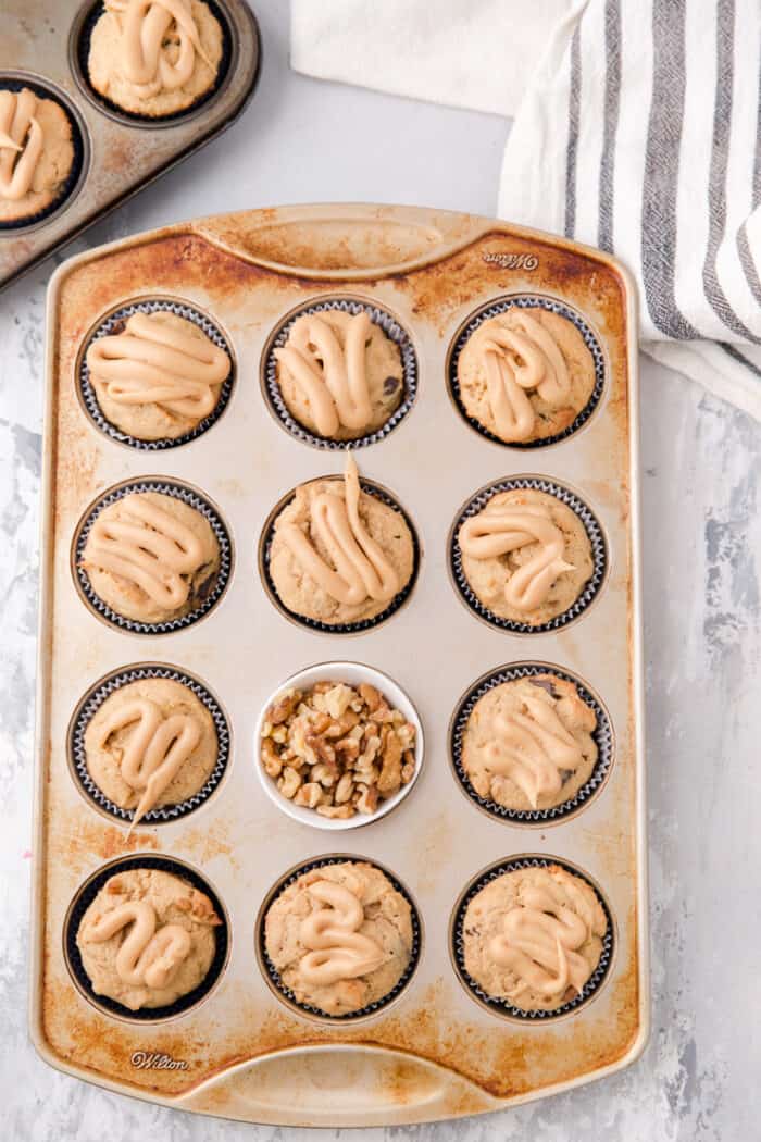 tin of banana muffins with nuts in the center cup