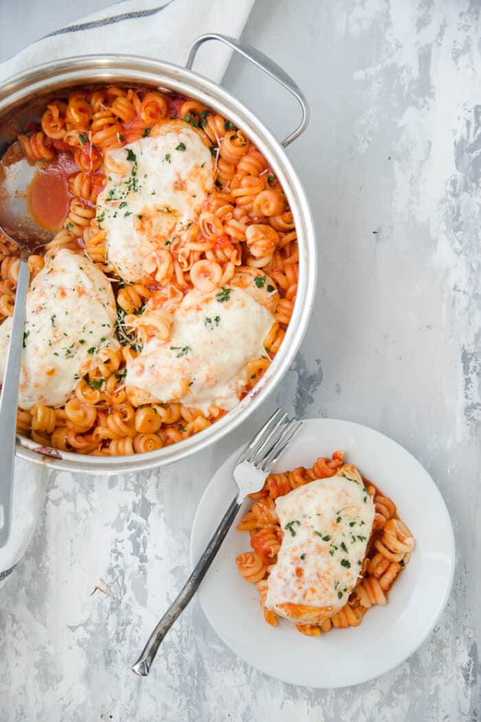 baked chicken parmesan skillet with a served bowl on the side