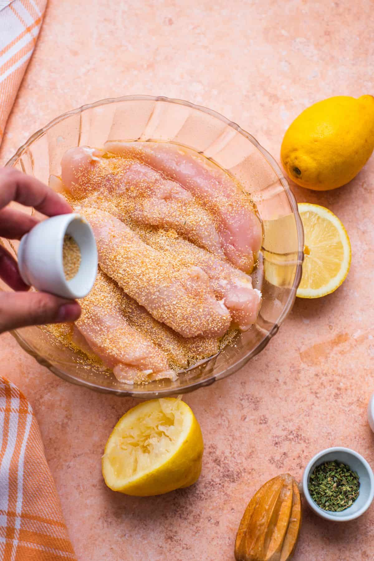 add seasonings to raw chicken in bowl