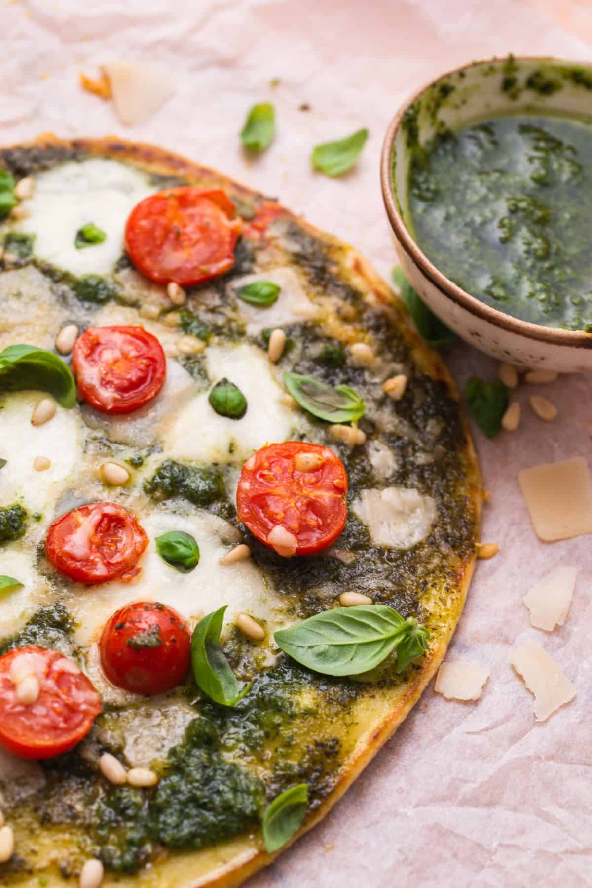 pizza with pesto sauce and cherry tomatoes