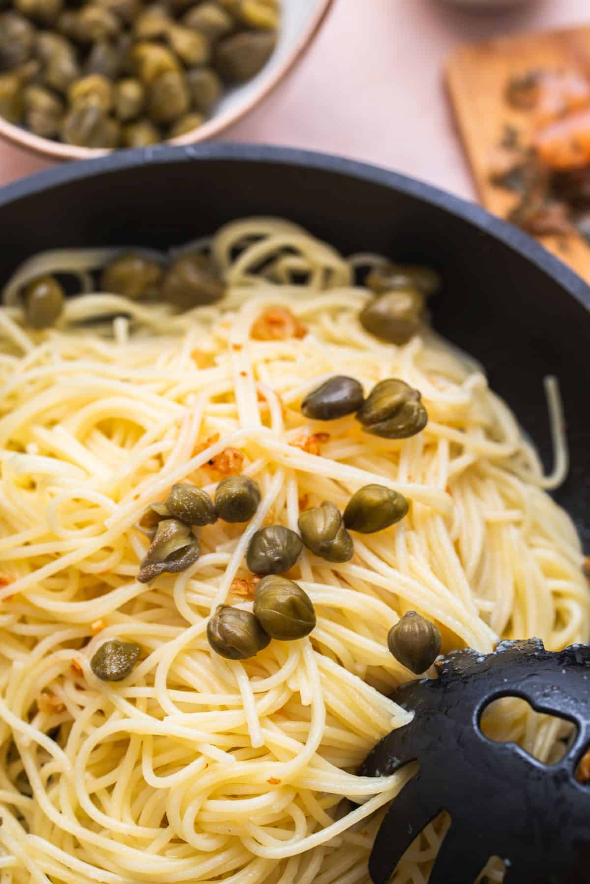 pasta noodles in pan with capers