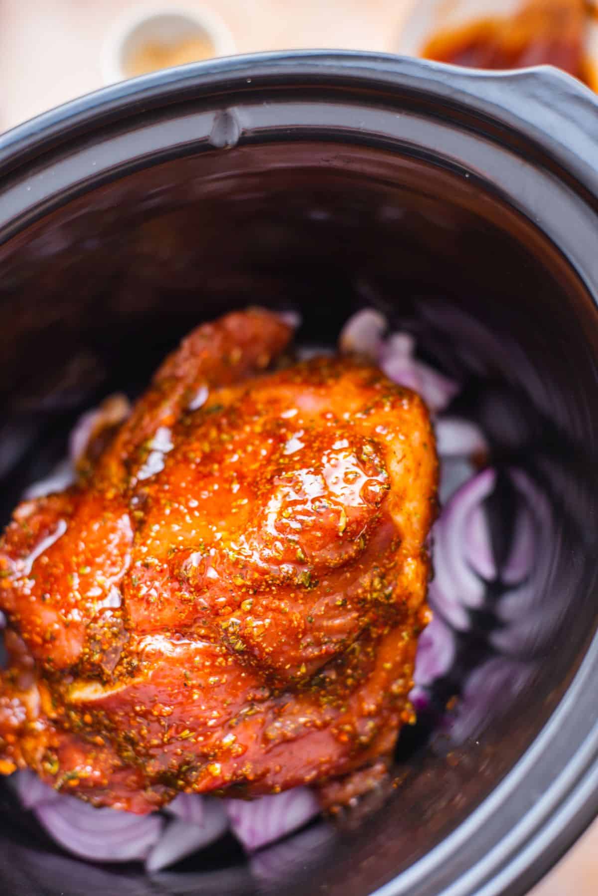 marinated pork roast over raw red onions in slow cooker