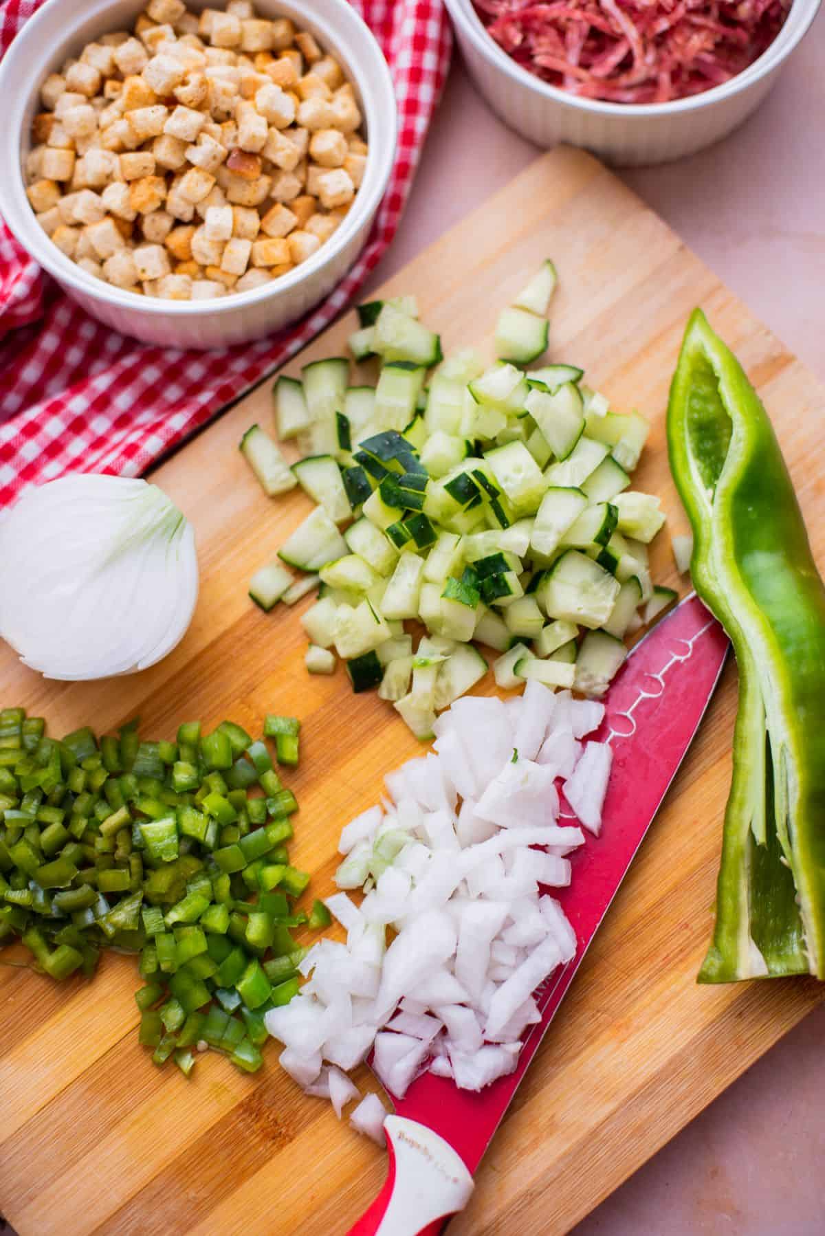 knife with chopped onions, cucumbers, and green pepper